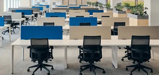 Modern open-plan office space featuring clean workstations, ergonomic chairs, and sanitized carpets provided by professional office cleaning services in Sioux Falls, SD.